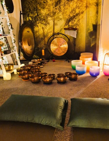 Studio with gongs and singing bowls on the floor in front of two pillows