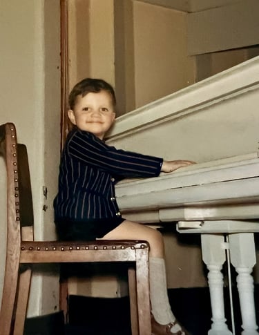 Jon Yon playing a grand piano at a very young age