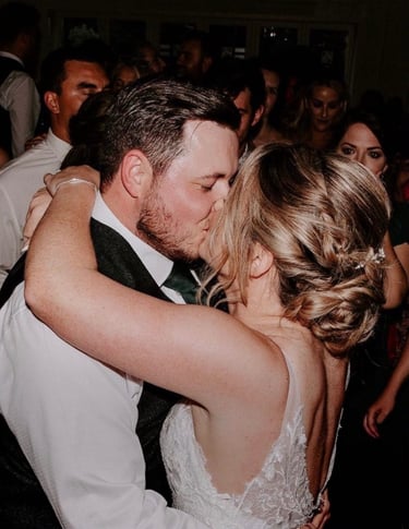 a bride and groom kissing on the dance floor