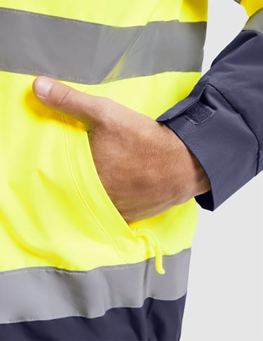 Imagen de una mano en el bolsillo de una prenda de alta visibilidad.