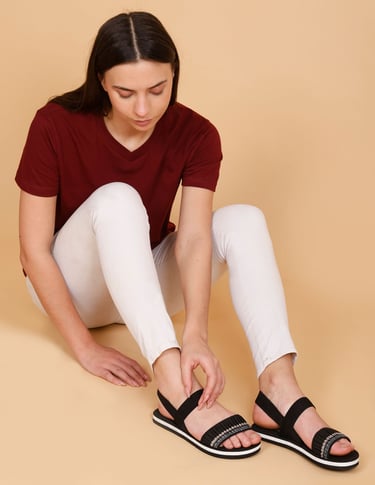 a woman looking her embroided black sandal