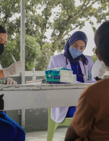 Dokter wanita berjilbab dan bermasker memberikan konsultasi kesehatan kepada anak di area terbuka