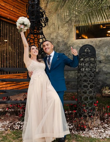 Recién casados celebrando sonriendo a cámara. La novia levanta el ramo y disfrutan de su momento juntos en Quito, Ecuador
