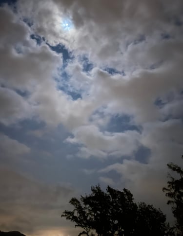 a cloudy sky with a few clouds and a few trees
