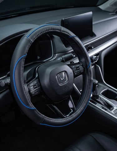 Black leather steering wheel cover with blue trim installed in a modern Honda vehicle interior.