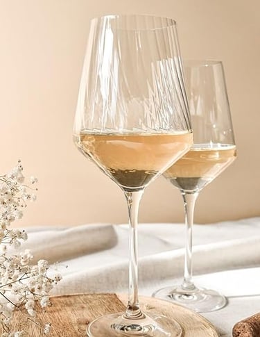 Textured crystal wine glasses set on a neutral-toned dining table.
