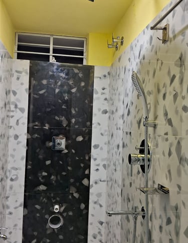 A bathroom with white tiles and a shower and window on top