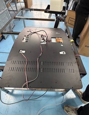stacks of raw J-Curve monitor frames at ClaraTech factory for precise curvature matching.
