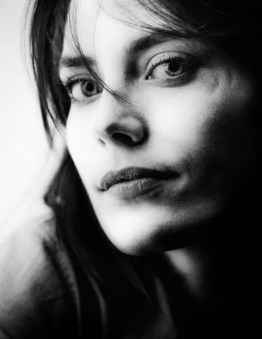 Close-up black and white portrait of a young woman with a thoughtful expression.