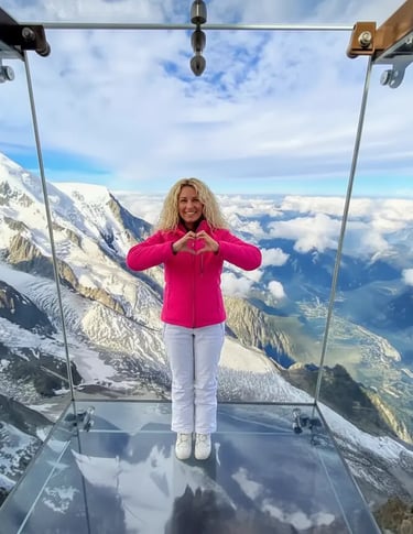 Woman making heart hands in Aiguille du Midi glass skywalk, Chamonix.