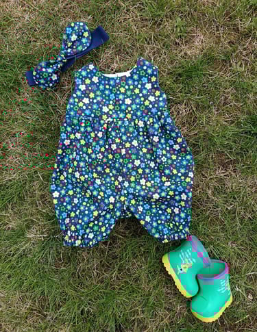 Wollyonline BD1624 view E romper in dark floral print with matching hair bow