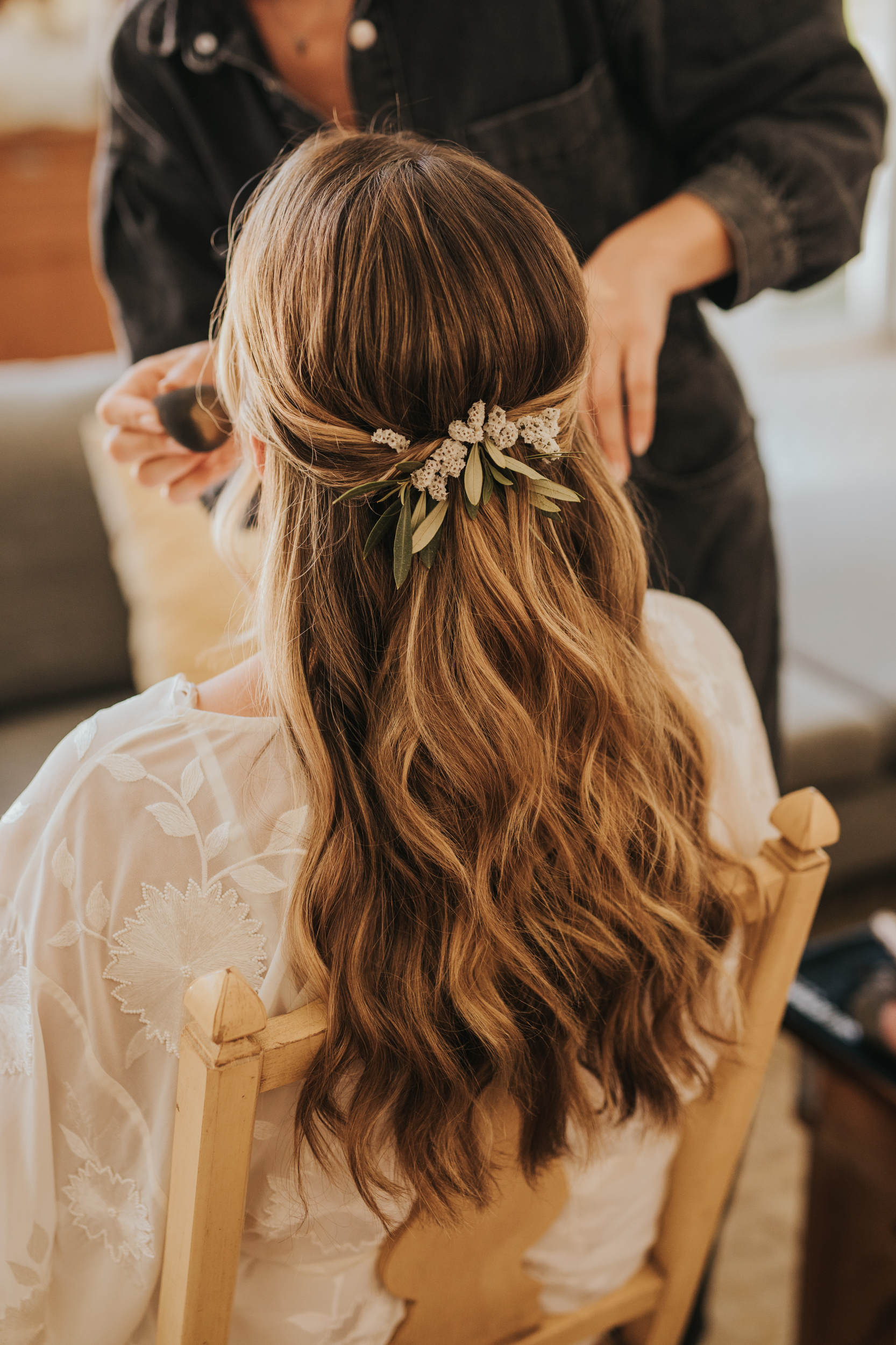 Simple effortless hairstyle for a bride decorated with natural flowers
