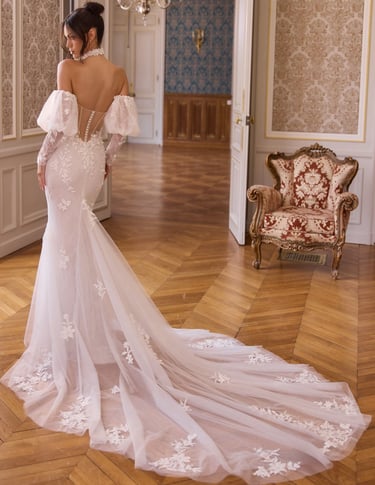 Elegant mermaid wedding dress with lace floral details, off-the-shoulder sleeves, and a long tulle train.