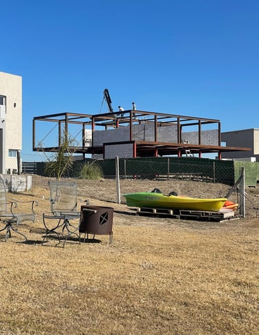 Un hombre de pie en una cubierta con un barco al fondo.