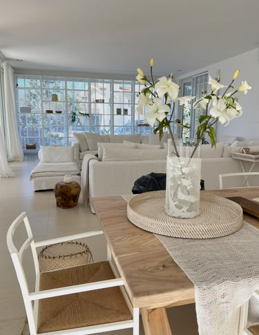a table with a vase of flowers in a living room