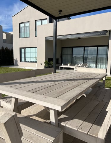 Una mesa con una mesa y sillas frente a una casa.