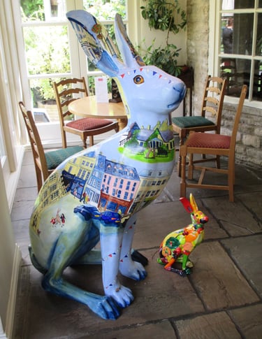 Hare sculpture featuring Cirencester scenes, painted by Laura Fearn