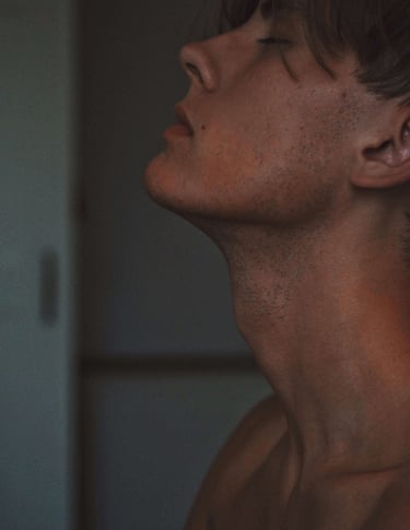 a white man with eyes closed and head tilted upwards, reflecting