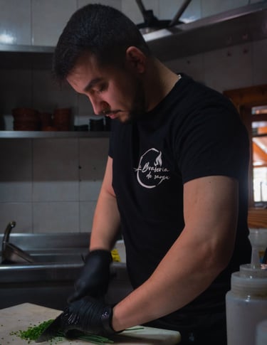 a man in a black shirt is cutting up some vegetables