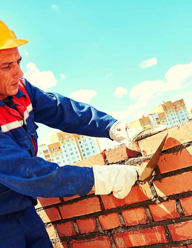 um homem com um macacão azul de trabalho e um capacete amarelo