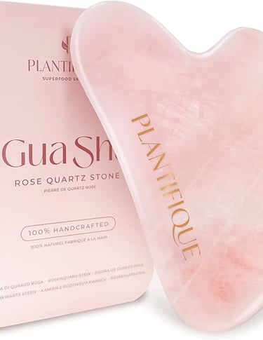 Piedra Gua Sha de cuarzo rosa utilizada en rutinas faciales para mejorar la circulación, reducir la 