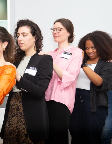 Women showing their support with hands on the backs of other women, female empowerment workshops. 