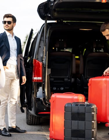Sri Lankan driver loading luggage into a private tour car for two tourists during a Colombo Airport 