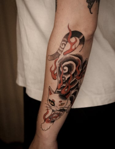 tattoo sur l'avant bras d'un chat stylisé en tatouage traditionnel japonais
