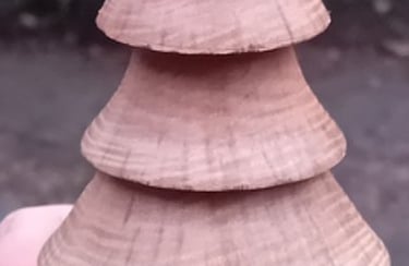 Hand holding a turned wooden fir tree