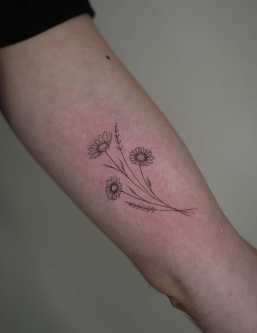 Tatuaje fineline en Madrid de tres amapolas con tallo largo y pétalos finos en composición botánica 