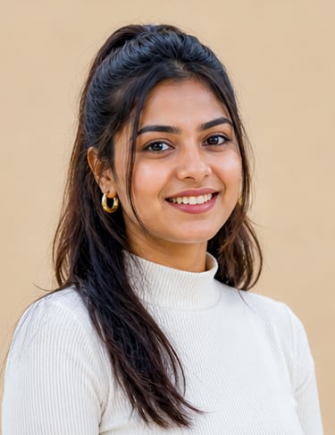 Smiling young South Asian woman wearing a white turtleneck and gold hoop earrings.