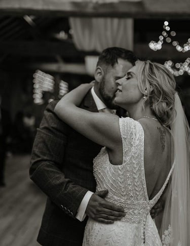 a bride and groom kissing in a barn wedding