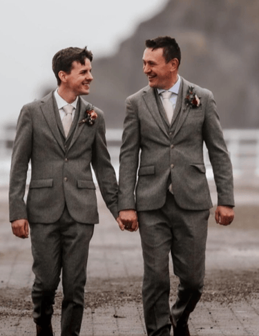a couple of men in suits walking down a path