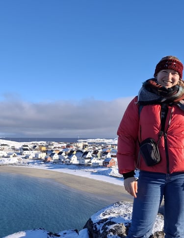 a woman standing in the arctic with a beautiful view