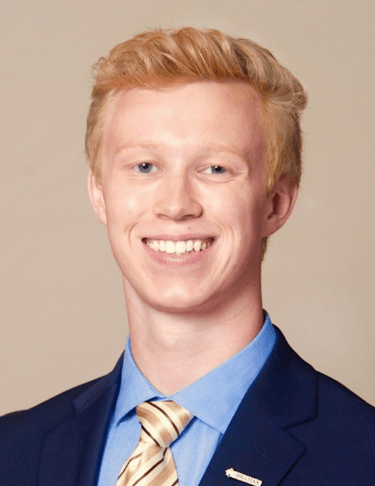 a man in a suit and tie smiling - Branden Denchfield