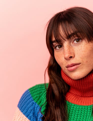 a woman with long hair and a colorful sweater