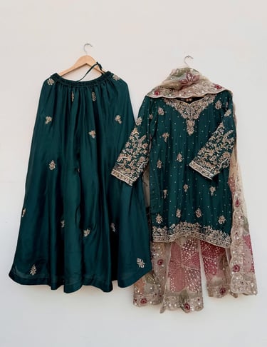 Bottle green silk lehenga choli with gold zari embroidery and a floral net dupatta.
