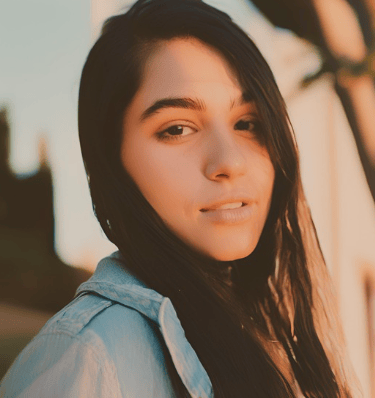 Young woman with dark hair and blue shirt with a smile sharing review for Breathe Thru Recovery