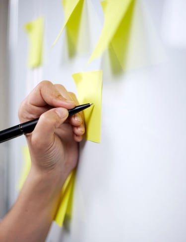 Team of educators planning strategy, writing on whiteboard or desk with documents, educational project planning
