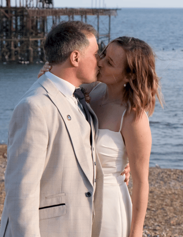 A bride and groom kissing on the beach