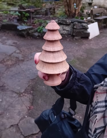 Hand holding a turned wooden fir tree