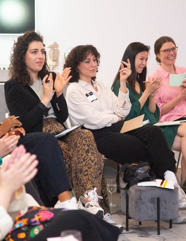Women applauding for other women at public speaking workshop