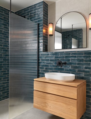 deep, glossy teal metro tiles, laid in a horizontal stack with white grout and oak floating vanity