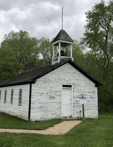 A white wooden church with a bell