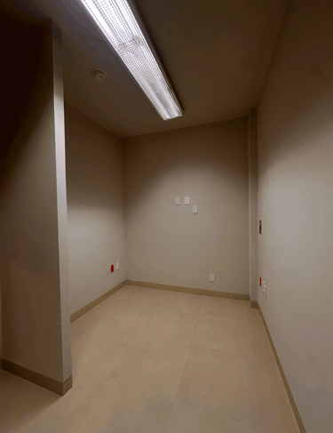 Cuarto vacío con muros beige y luminaria LED central en plafón | KARÄNA