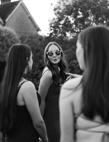 black and white image of a girl with sunglasses looking and the camera