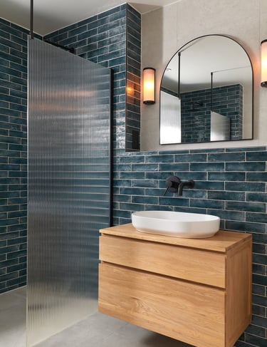 deep, glossy teal metro tiles, laid in a horizontal stack with white grout and oak floating vanity