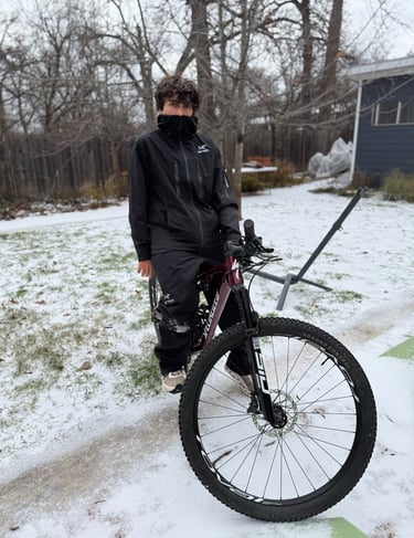 man in black on bike in snow
