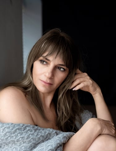 a woman in a blue dress sitting on a bed