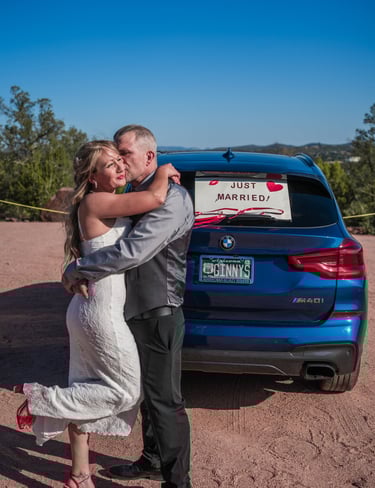 a man and woman standing in front of a car